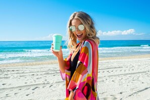 Una playa cerca, arena blanca, sombrillas, toallas de playa