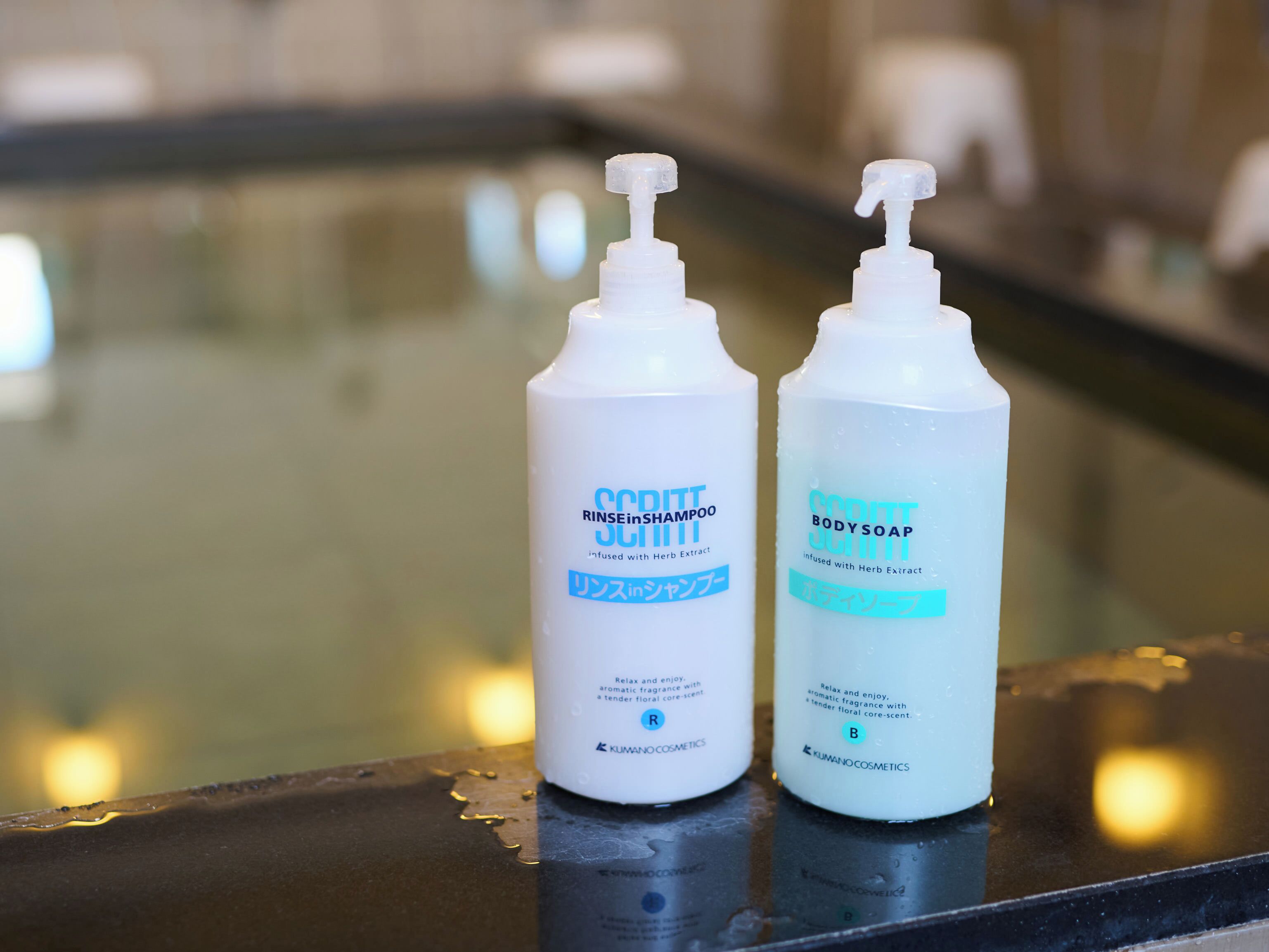 Two bottles of Scott Body Soap and Scott Rinse in Shampoo on a reflective surface.