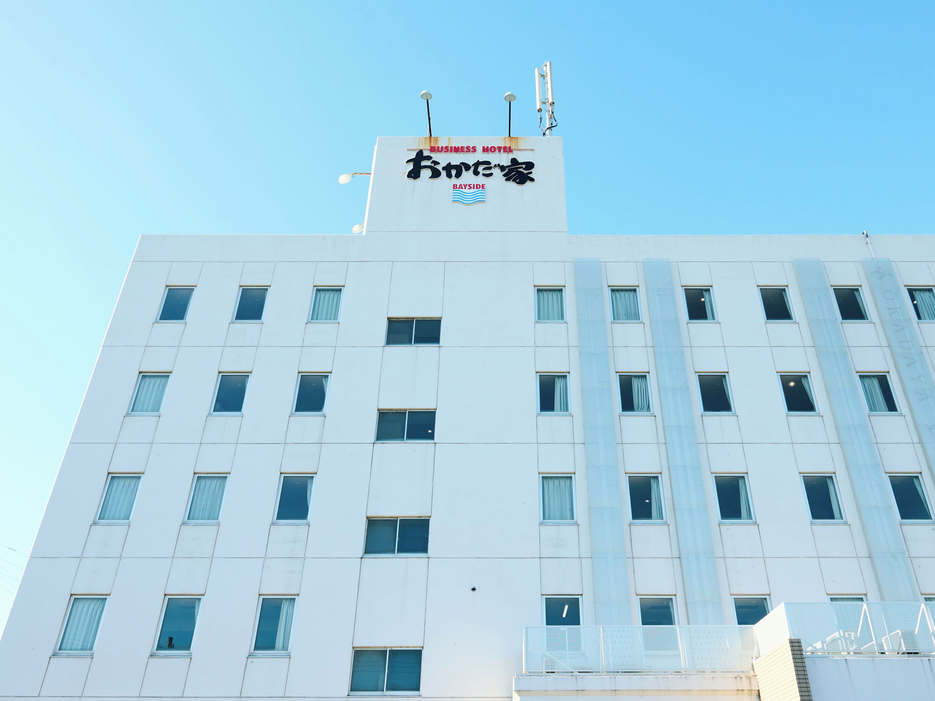 A modern hotel building with a flat facade, multiple windows, and a sign indicating it is a business hotel.