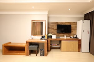 A modern kitchen with a wooden countertop, built-in appliances, and a flat-screen TV mounted above the counter.