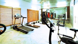 Una palestra con attrezzature per esercizi, tapis roulant e cyclette.