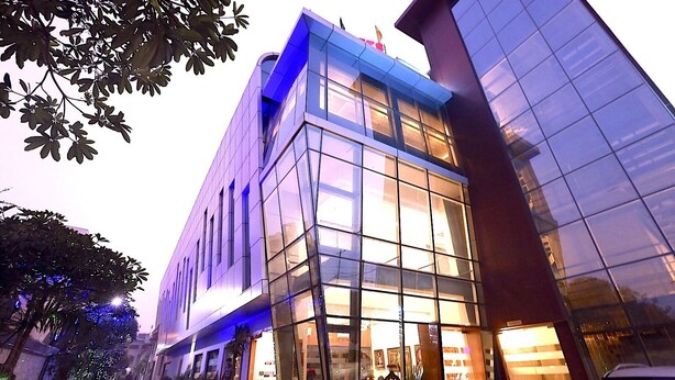 Un edificio moderno con ampie vetrate e un angolo illuminato di blu.