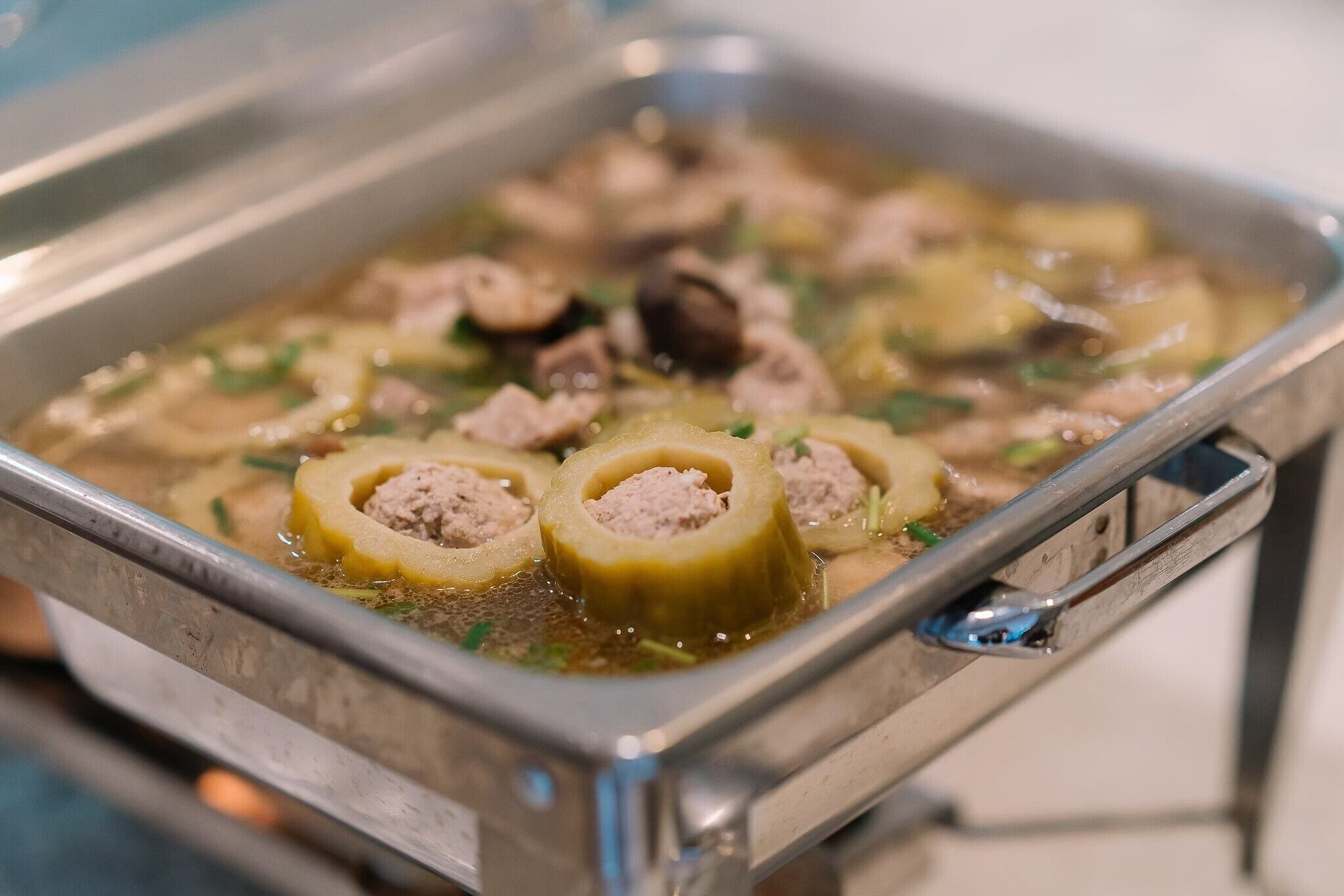 Una bandeja de comida con albóndigas y verduras en caldo.