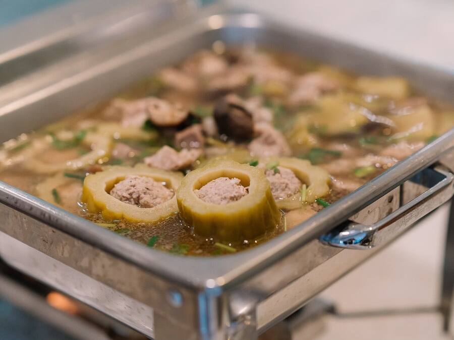 Una bandeja de comida con albóndigas y verduras en caldo.