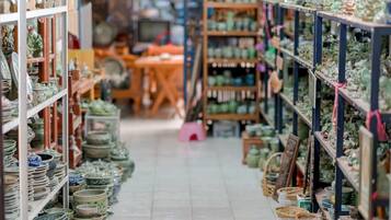 A narrow aisle in a store with shelves on both sides displaying various ceramic items.