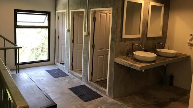 A modern bathroom with two sinks, a large window, and a staircase. - Hub of Joys Hostel (Ko Lanta)