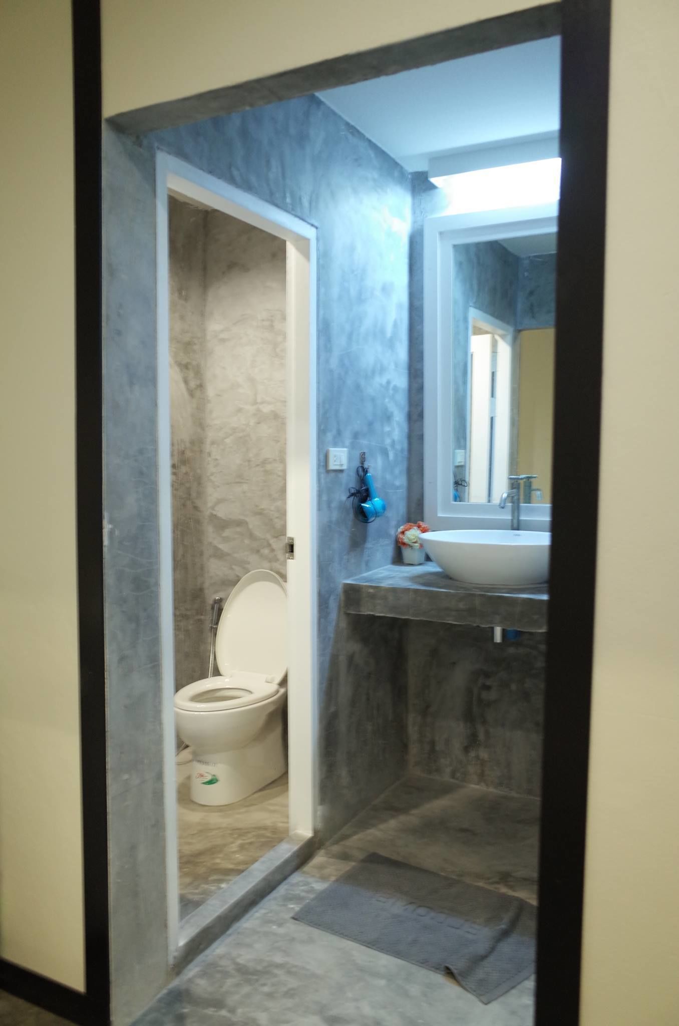 A bathroom with a toilet, a sink, and a mirror.