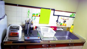 Une cuisine équipée d’un four à micro-ondes, d’un grille-pain, d’une balance et de divers ustensiles de cuisine.