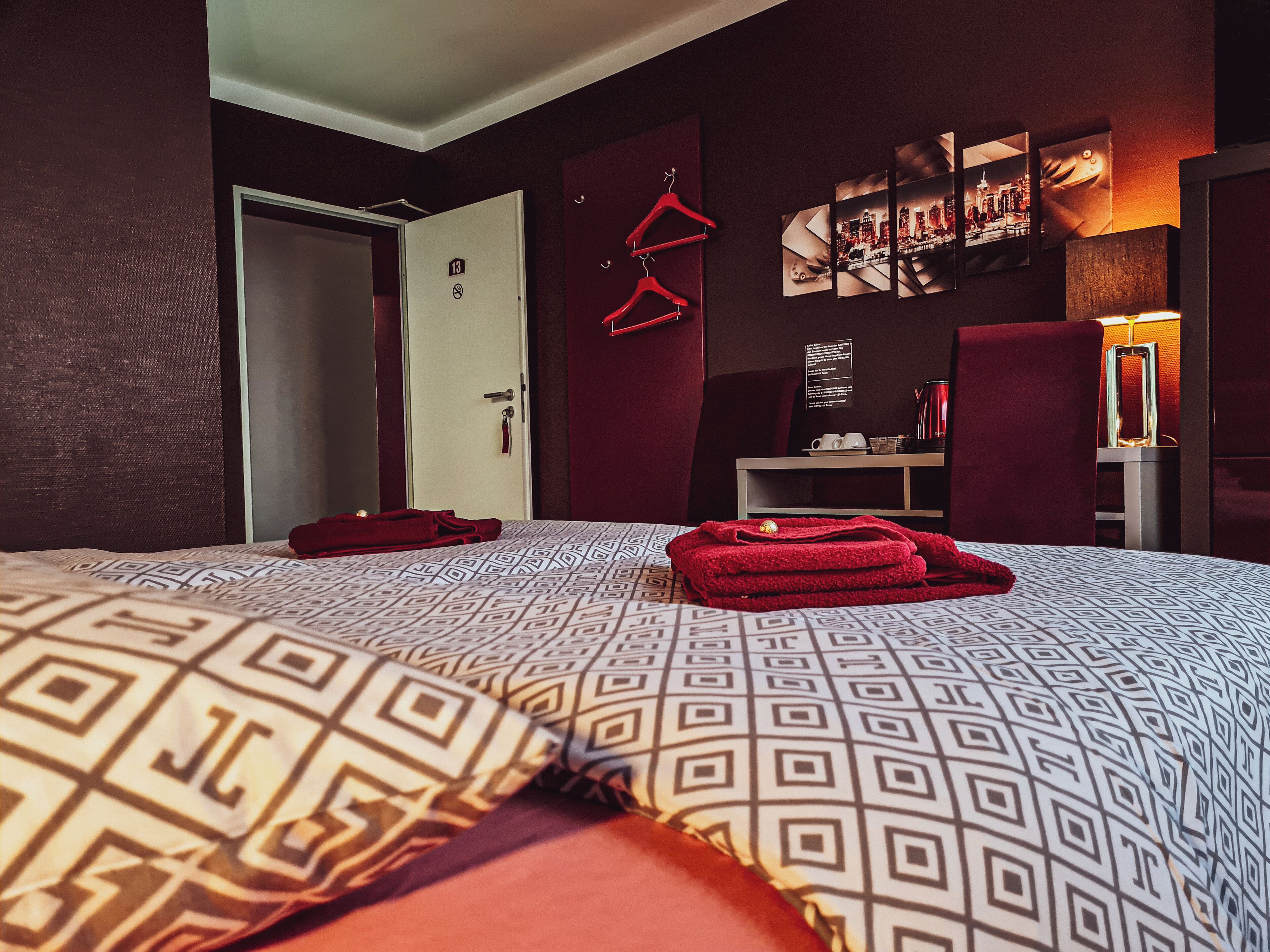 Een hotelkamer met een bed, een kledingkast, een bureau en een stoel.