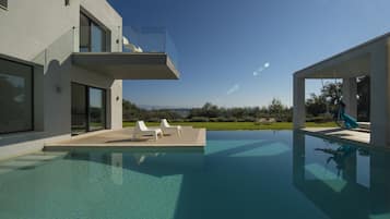 Una piscina al aire libre, sombrillas, tumbonas