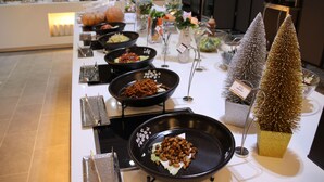 A buffet table with various dishes and decorative elements.