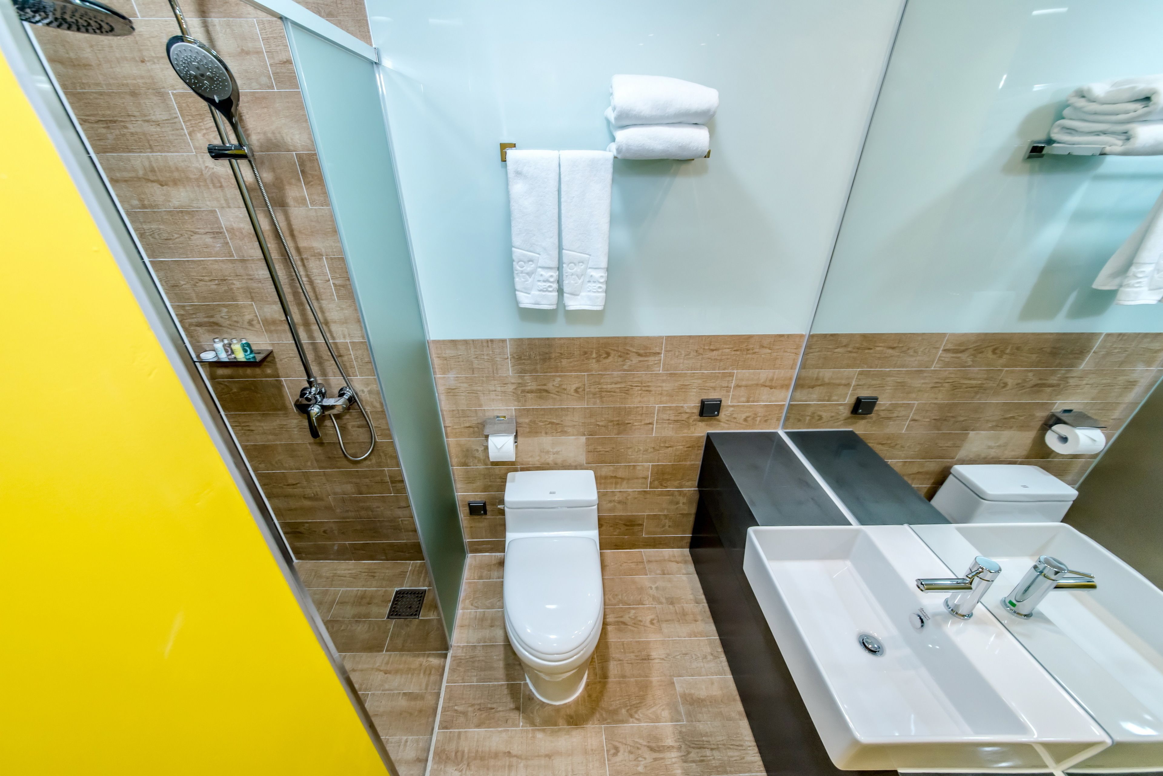 Un baño moderno con ducha, inodoro y lavamanos.