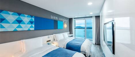 A modern hotel room with two beds, a large window with a view, and a geometric wall design.