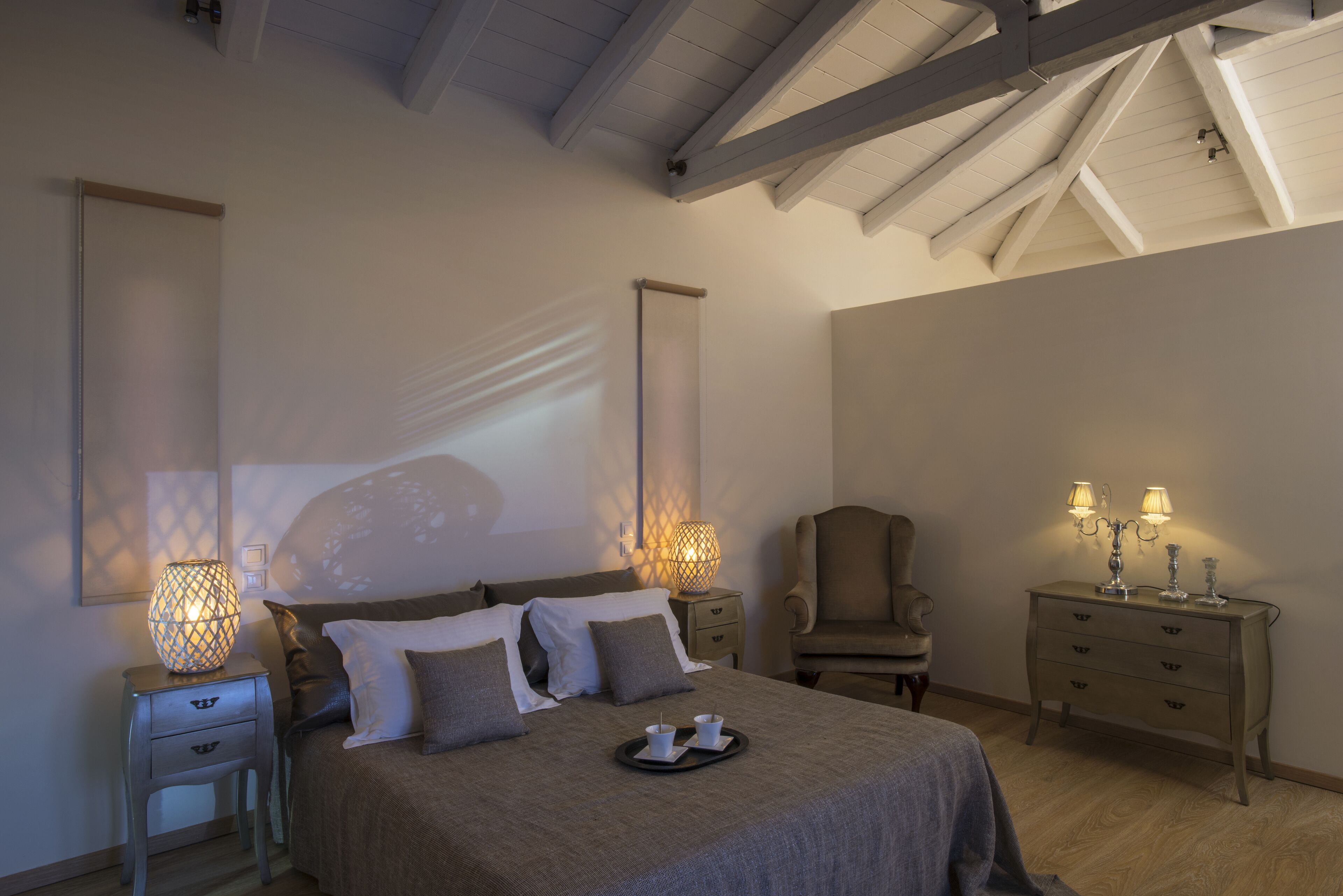 Une chambre à coucher avec un lit, des tables de chevet, une commode et une chaise.