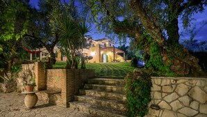 Una escalera de piedra que conduce a una casa con un muro de ladrillo y un jardín.