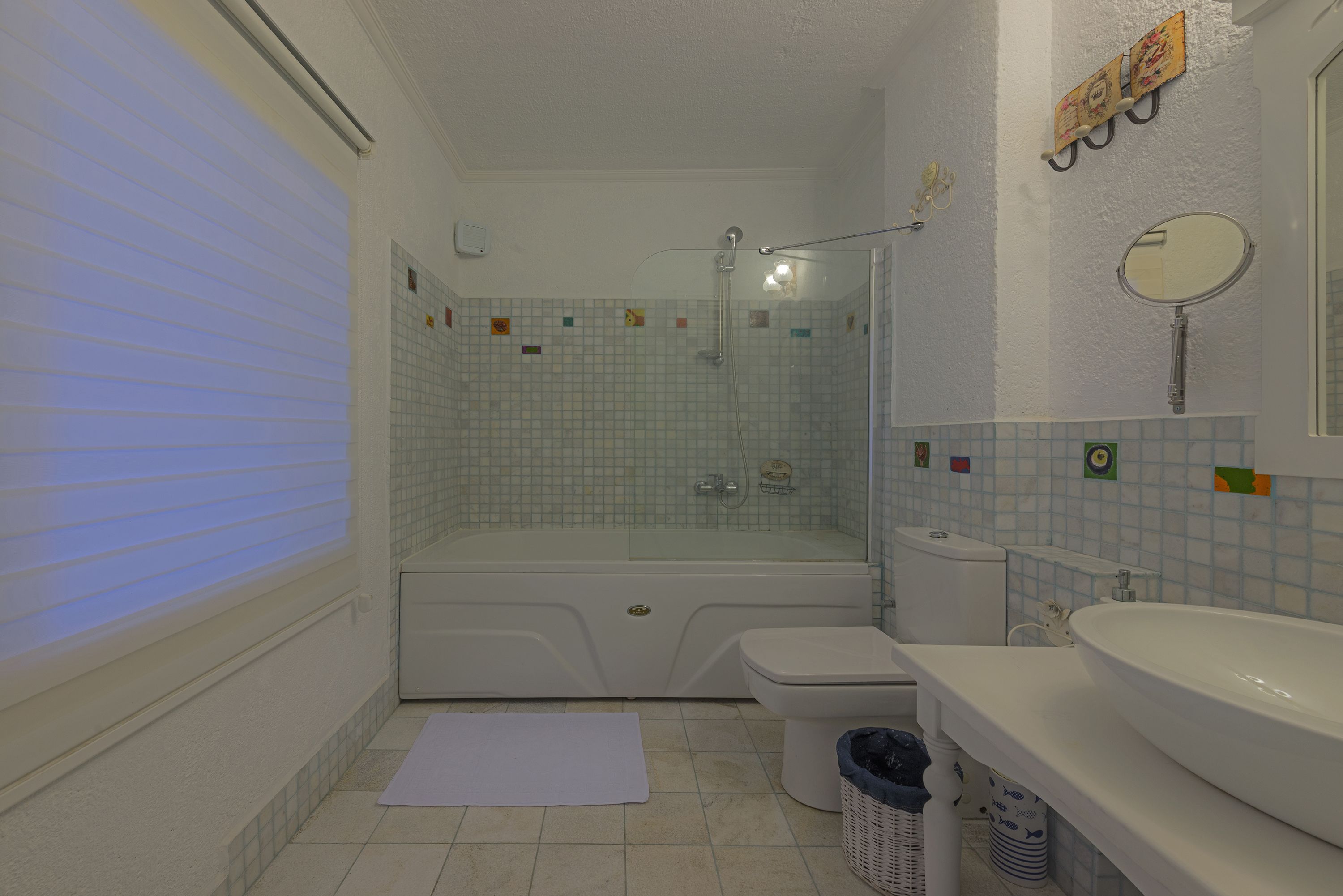A bathroom with a bathtub, toilet, sink, and a shower area.