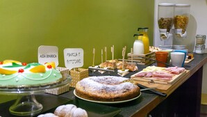 A buffet with various food items and a cake on display. - Piazza Marina (Palermo)