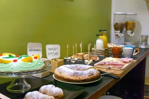 Un buffet con diversi cibi e una torta in mostra.