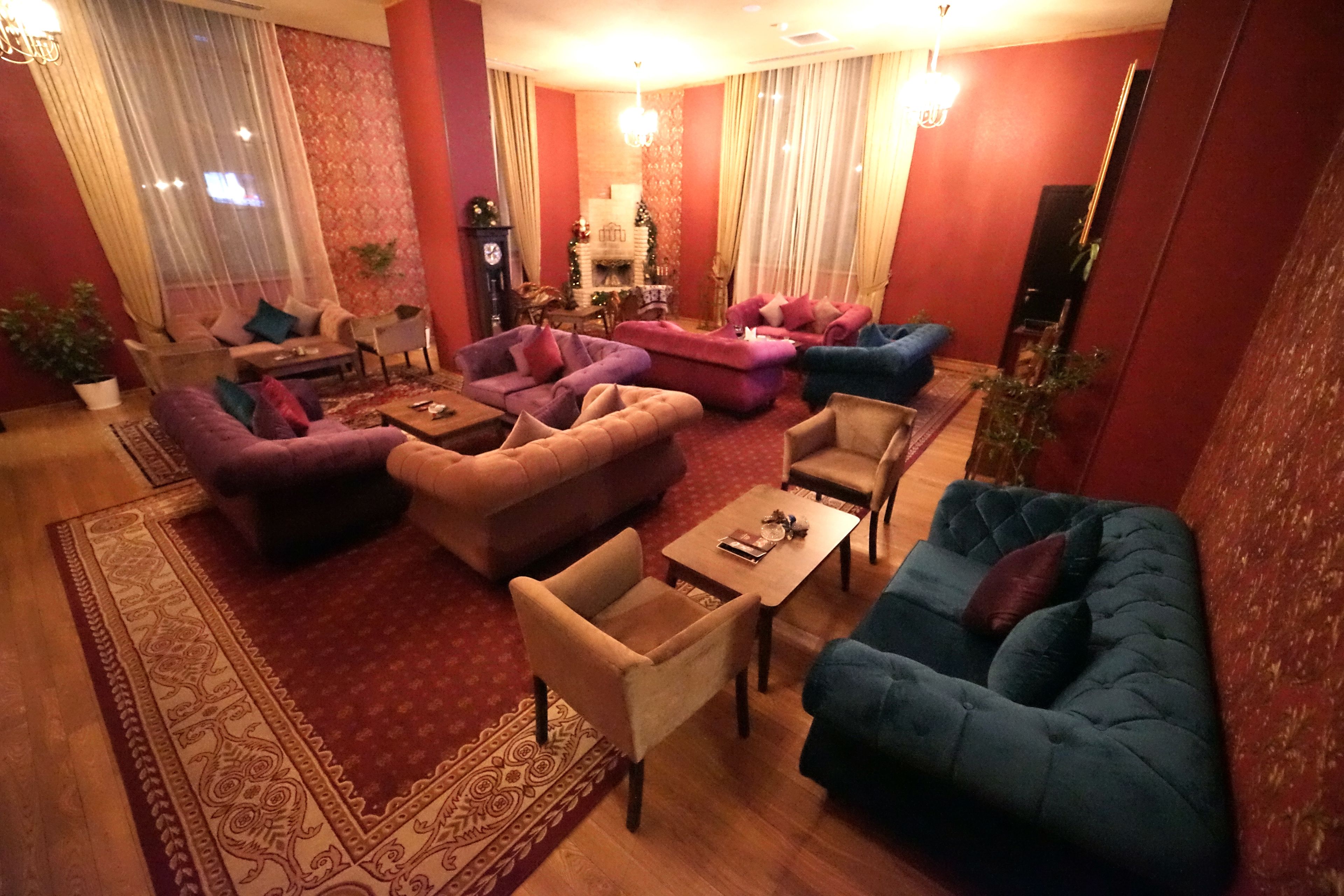Een ruime woonkamer met meerdere banken, een salontafel en een open haard.