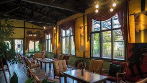 A restaurant with wooden furniture, large windows, and hanging lights. - Club Afrodit (Edremit)