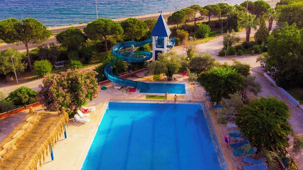 A resort with a swimming pool, a water slide, and a beach view. - Club Afrodit (Edremit)