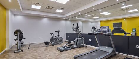 A gym with treadmills, stationary bikes, and a rowing machine.