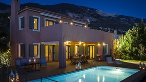 A modern two-story house with a swimming pool, outdoor furniture, and a mountain backdrop. - Villa Eleni (Kefalonia)