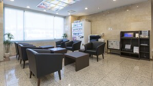 Un área de espera moderna con asientos cómodos, señal de Wi-Fi, máquina expendedora y un tablón de anuncios.