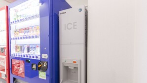 Una máquina expendedora con el logotipo de Coca-Cola y el logotipo de Wonda Coffee, y un equipo refrigerador ICE.