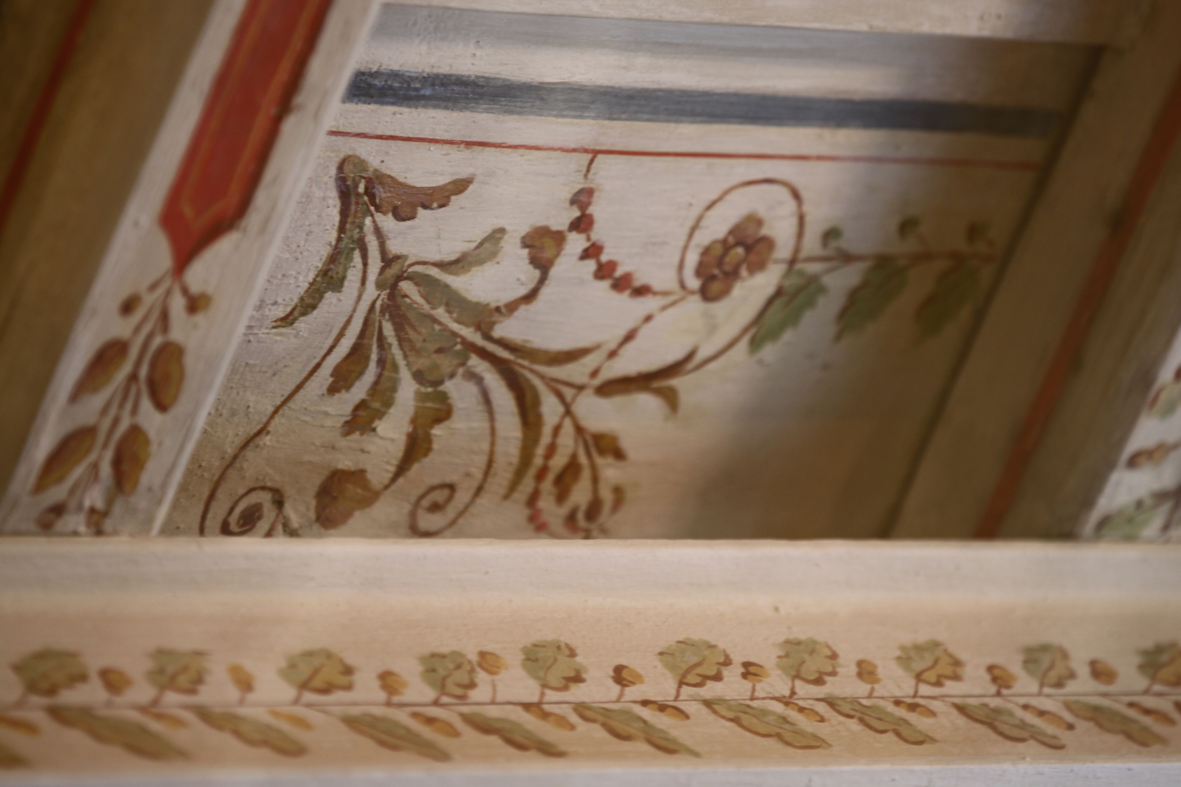 Primer plano de un techo decorativo con motivos florales y un borde a rayas.
