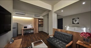 Studio, 1 Queen Bed | Living area | LED TV, fireplace - Tropics Eight Suites (George Town)