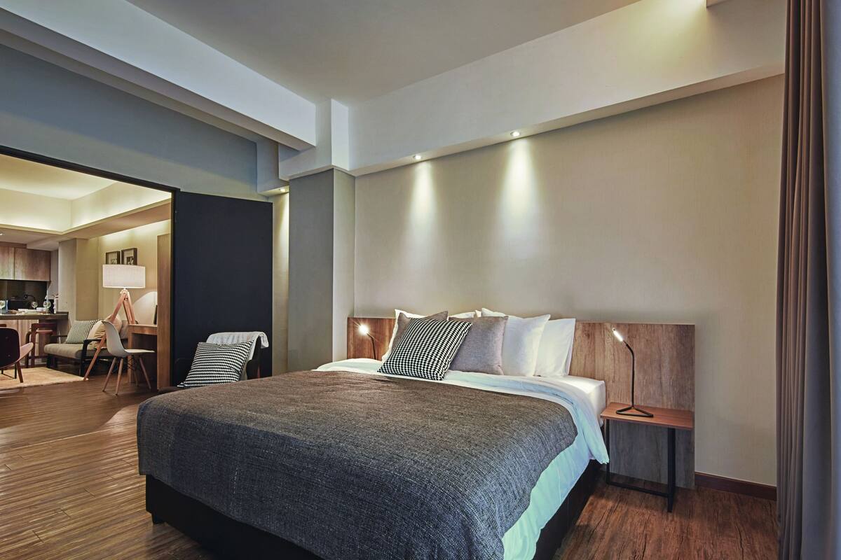 Ein modernes Hotelzimmer mit einem großen Bett, einem Schreibtisch und einem Essbereich.