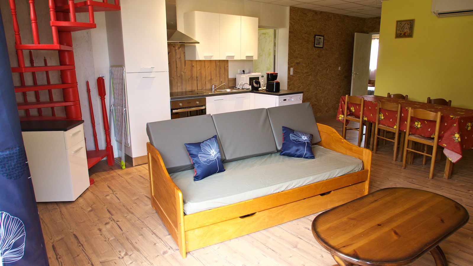 Una sala acogedora con un sofá, una mesa de centro de madera y una mesa de comedor con sillas.