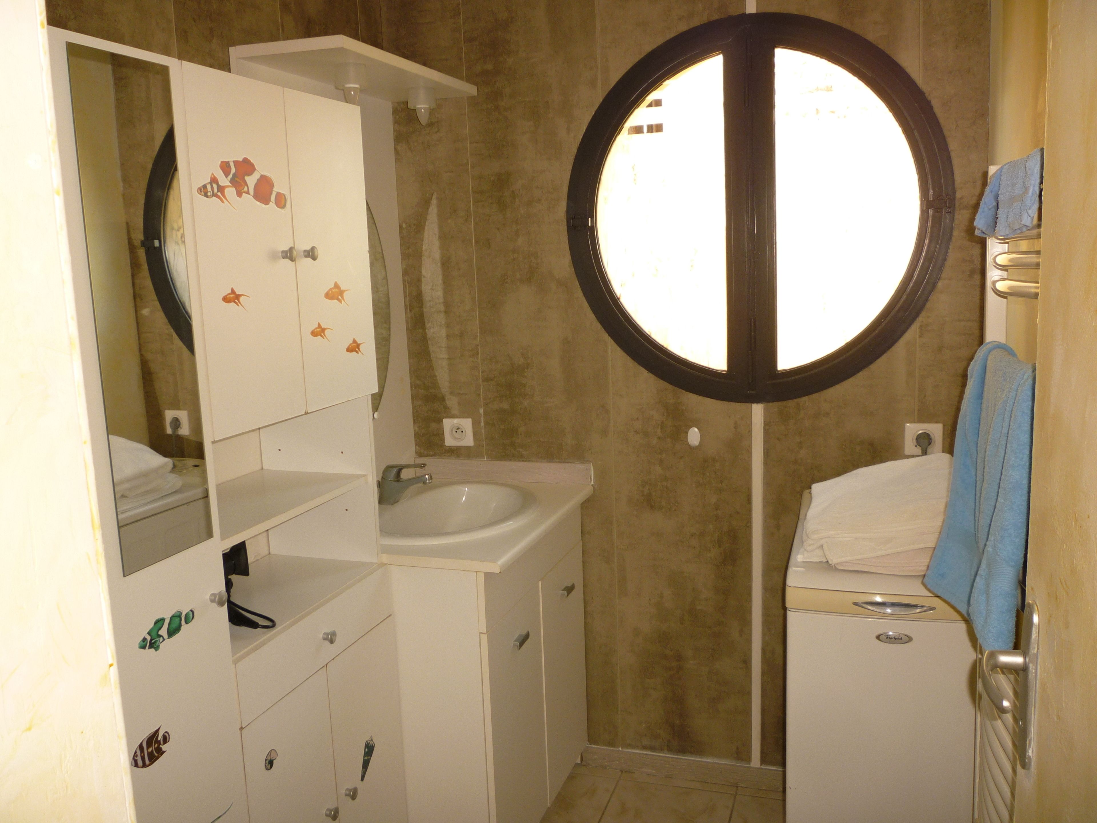 Casa de banho com lavatório, espelho e porta-toalhas.
