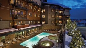 A hotel with a pool area, outdoor seating, and a Christmas tree. - Farwell Mountain 607 4 BedroomCondo By Moving Mountains (Steamboat Springs)
