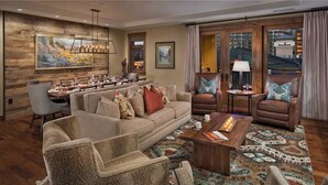 A spacious living area with a large sofa, two armchairs, a coffee table, and a dining table set for six. - Farwell Mountain 607 4 BedroomCondo By Moving Mountains (Steamboat Springs)