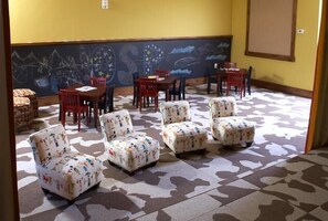 A room with patterned carpet, several chairs, and a table. - Mount Yale 611 4 BedroomCondo By Moving Mountains (Steamboat Springs)