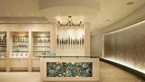 A modern hotel lobby with a central reception desk, a chandelier, and a wall with a textured design. - Mount Yale 611 4 BedroomCondo By Moving Mountains (Steamboat Springs)