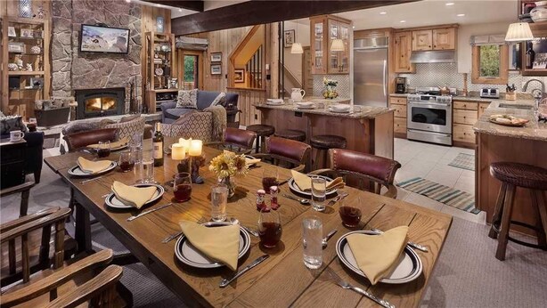 A spacious kitchen with a large island, wooden cabinetry, and a stone accent wall.