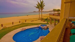A pool with a dolphin, a beach, and a view of the ocean. - Las Mananitas LM BB2 2 Bedroom Condo By Seaside Los Cabos (San José del Cabo)