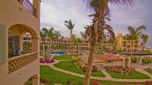 A resort with multiple buildings, a swimming pool, palm trees, and well-maintained gardens. - Las Mananitas LM BB2 2 Bedroom Condo By Seaside Los Cabos (San José del Cabo)