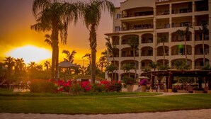 A hotel with multiple balconies, palm trees, and a sunset view. - Las Mananitas LM BB2 2 Bedroom Condo By Seaside Los Cabos (San José del Cabo)