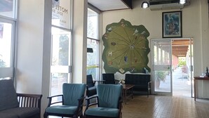 A hotel lobby with a large wall map, seating area, and a ceiling fan. - MOTEL DESA (Kuala Terengganu)