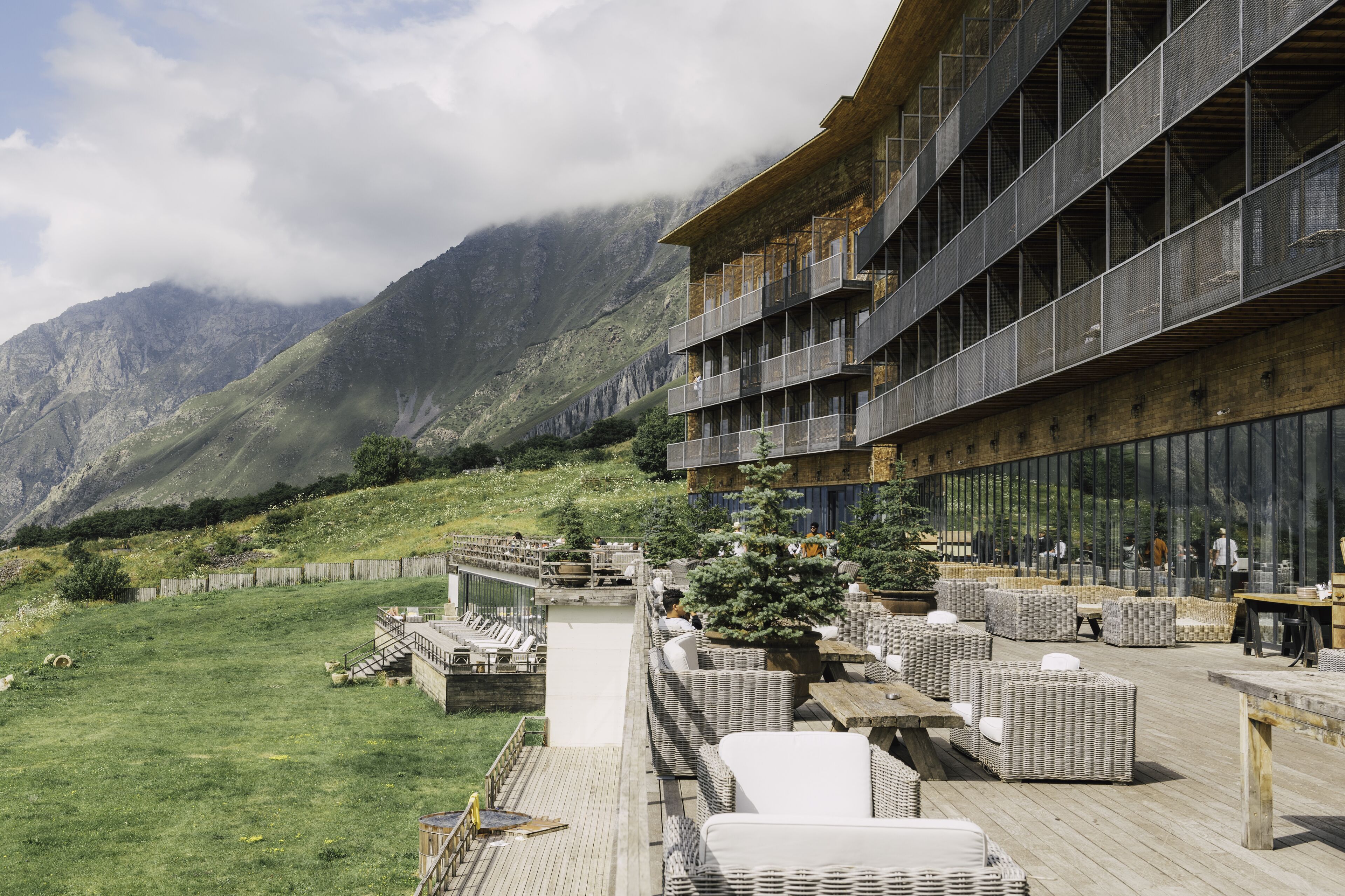 Un bâtiment moderne doté d’une terrasse et offrant une vue sur les montagnes.