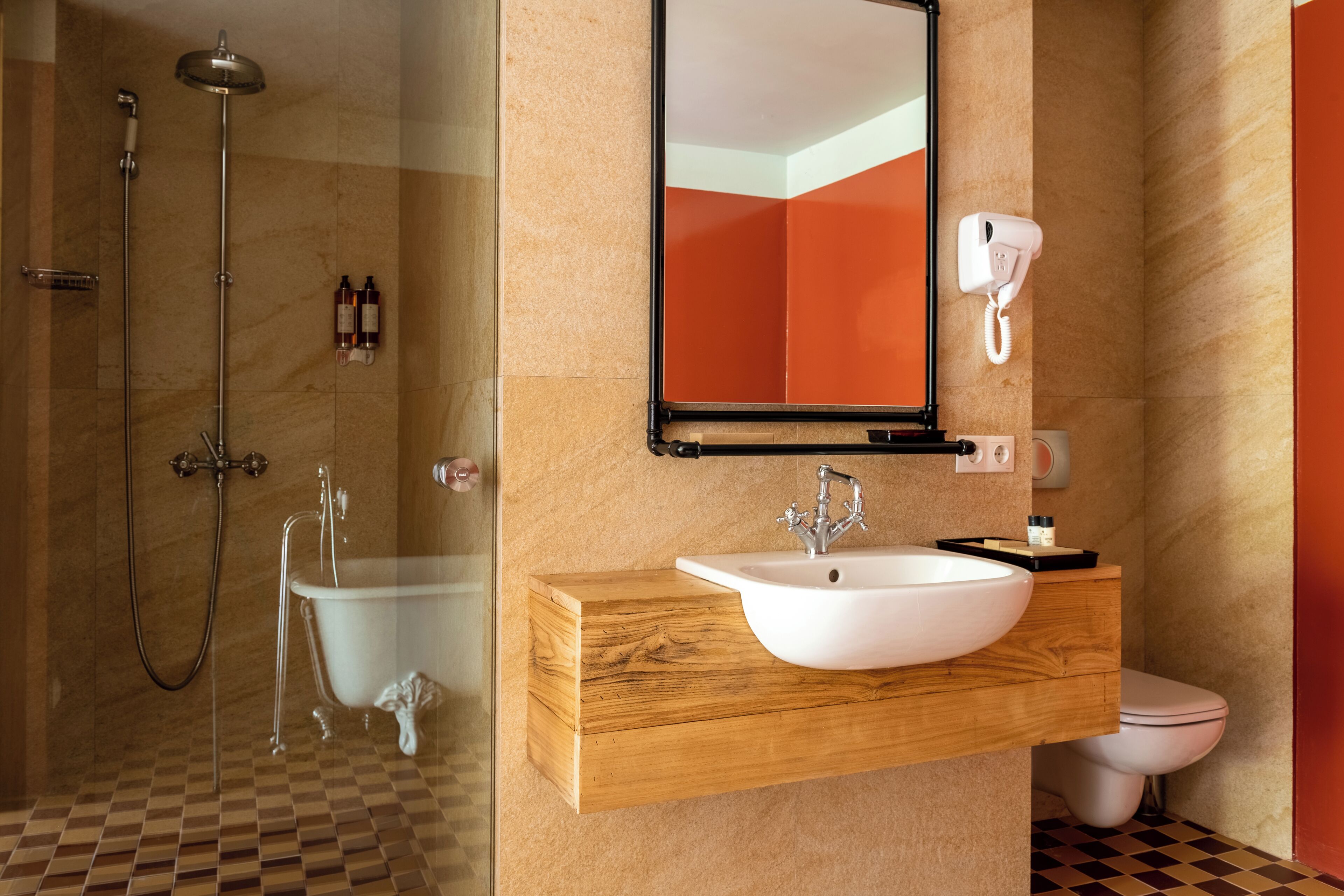 A modern bathroom with a freestanding bathtub, a sink with a wooden vanity, a toilet, and a shower with a glass door.