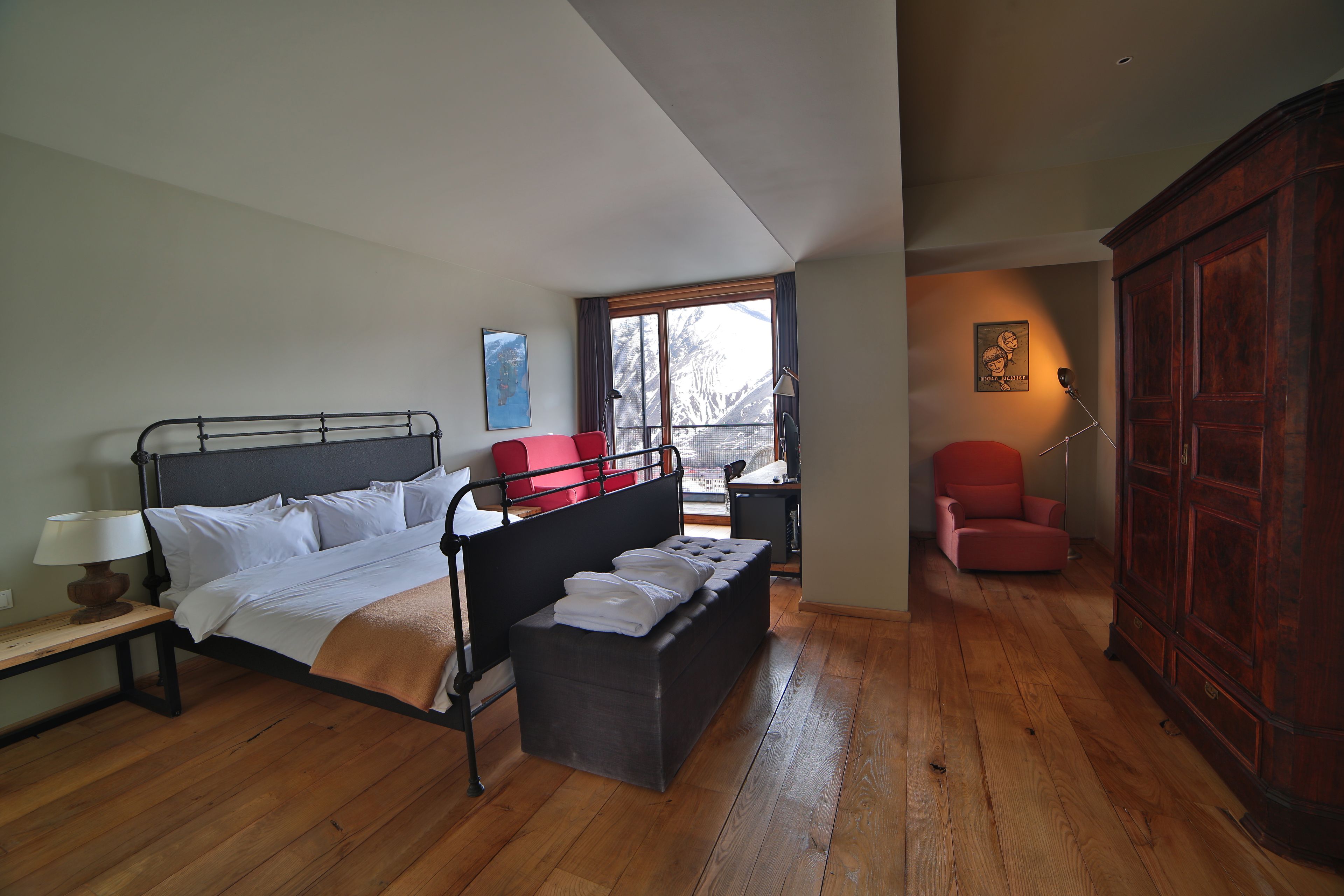 A bedroom with a bed, bedside table, and a wardrobe.
