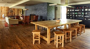 Enjoy meals around the large dining table, surrounded by comfortable seating and a cozy fireplace.