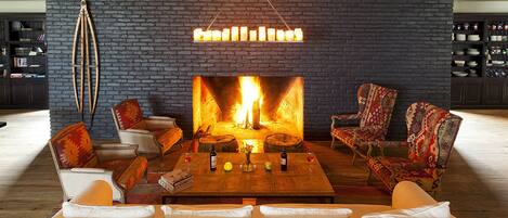 Una sala de estar acogedora con chimenea, asientos cómodos y una estantería.