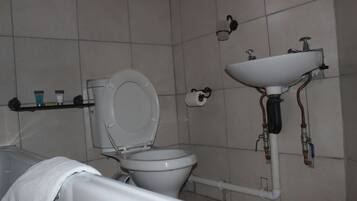 Ein Badezimmer mit Toilette, Waschbecken und Handtuchhalter.