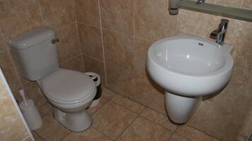 Une salle de bain avec des toilettes et un lavabo.
